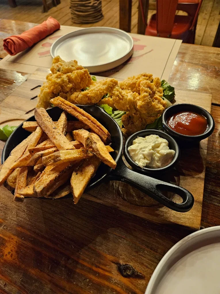 A fried platter with fries and dipping sauces in cast iron