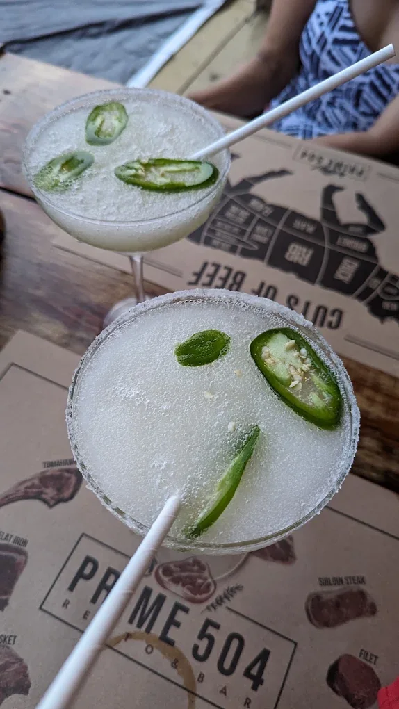Two frozen margaritas with salted rims and jalapeño slices on a Prime 504 placemat